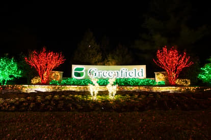 Holiday Lights in front of Greenfield Entrance sign with two reindeer